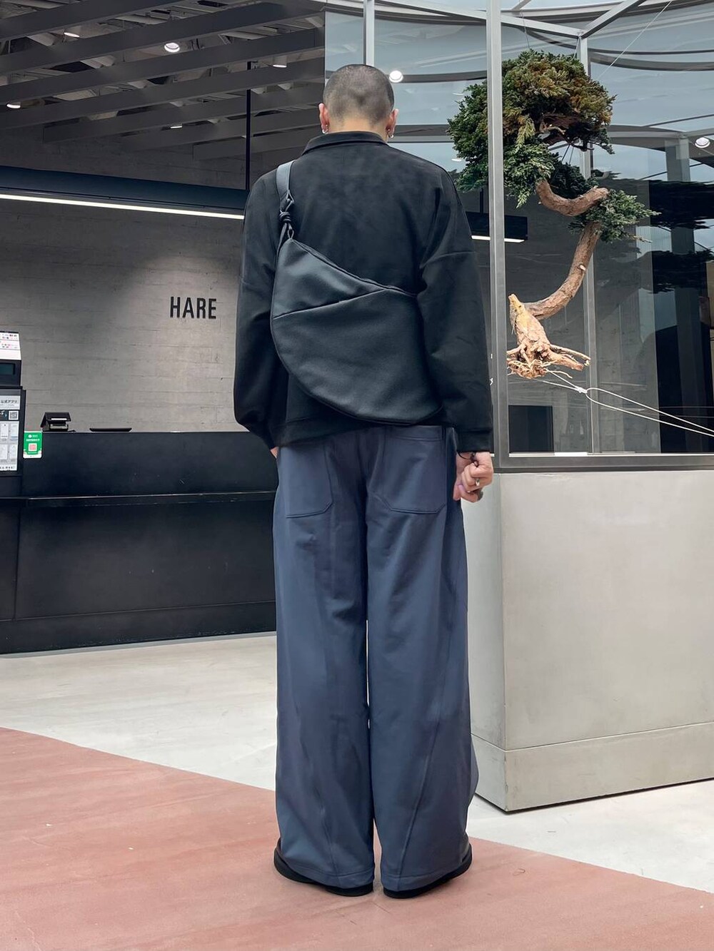 ブラック系のローファー、ブルー系のスウェットパンツ、ブラック系のショルダーバッグを着用したメンズの秋コーディネートの3枚目の写真