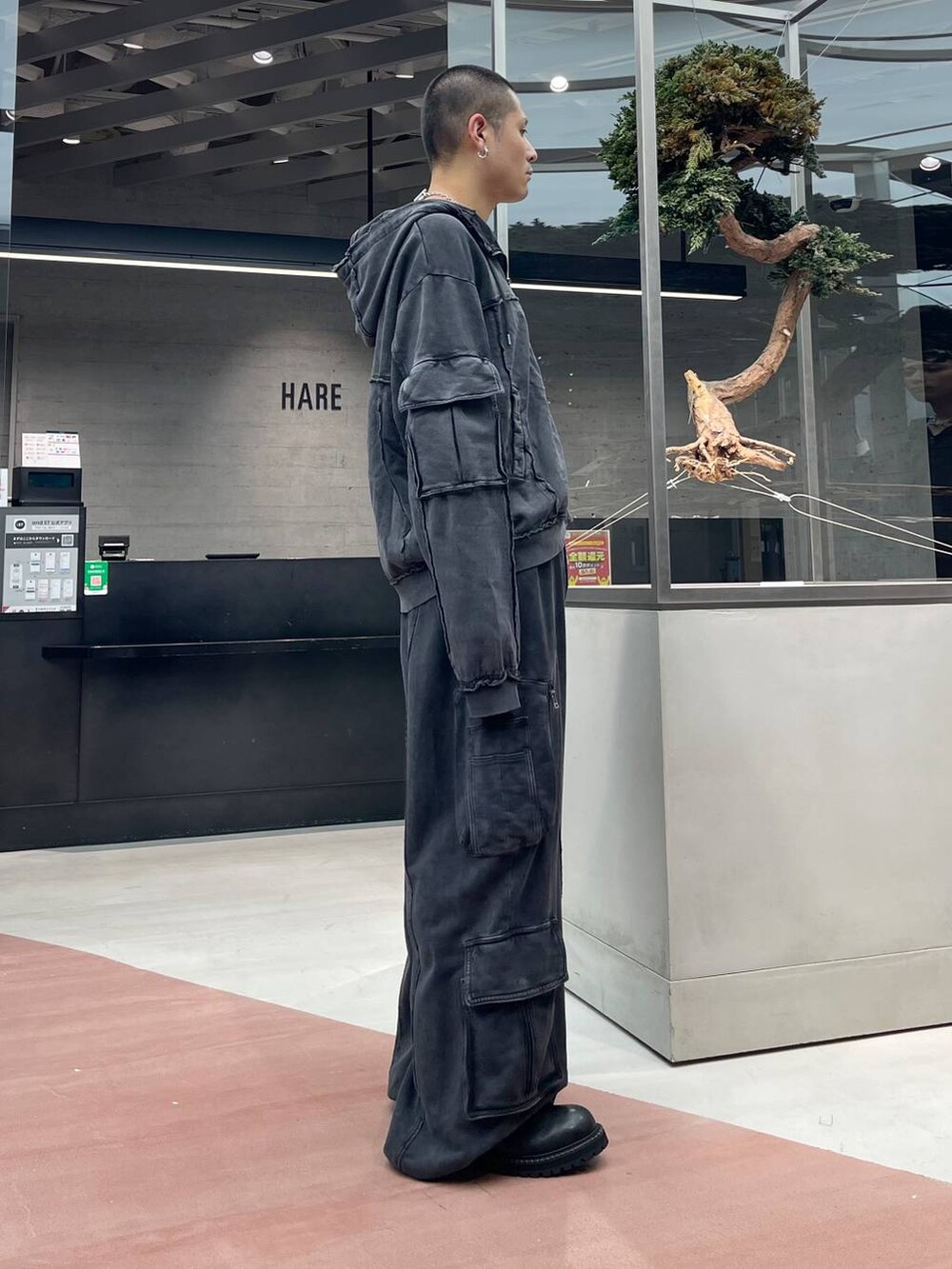 ブラック系のスウェットパンツ、ブラック系のパーカー、ブラック系のブーツを着用したメンズの秋コーディネートの4枚目の写真