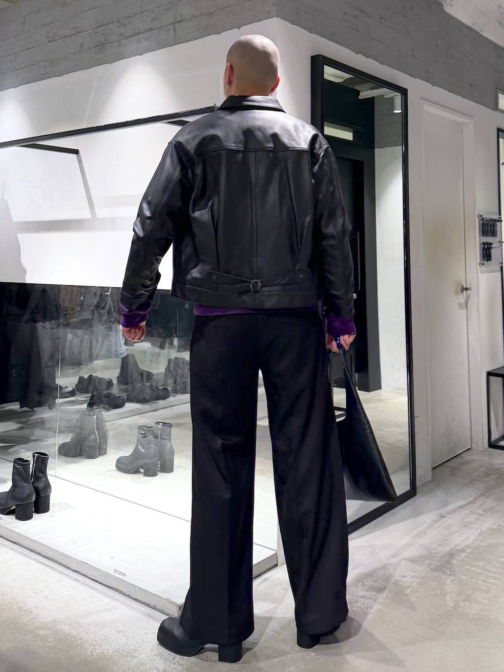 ブラック系のトートバッグ、ブラック系のブーツ、パープル系のスウェットを着用したメンズの冬コーディネートの4枚目の写真