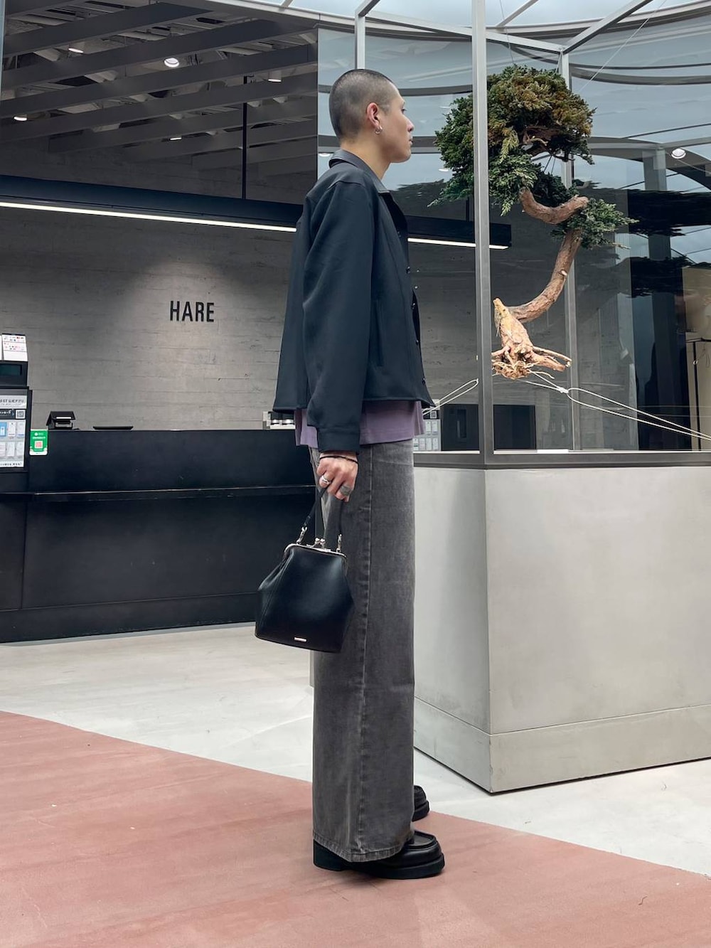 ブラック系のローファー、ブラウン系のデニムパンツ、ブラック系のショルダーバッグを着用したメンズの秋コーディネートの4枚目の写真