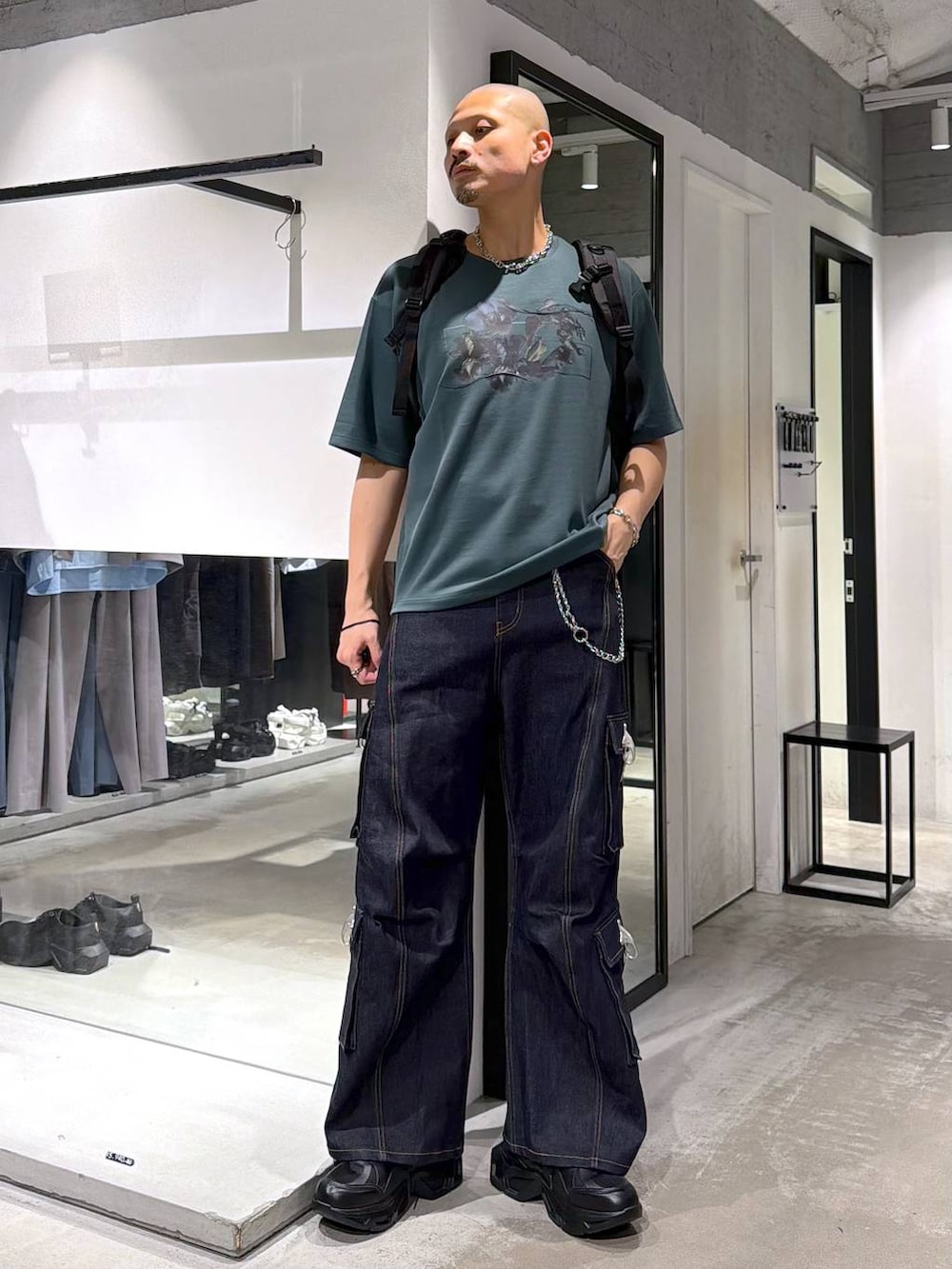 ブラック系のスニーカー、ブラック系のバックパック/リュック、ブルー系のデニムパンツを着用したメンズの夏コーディネートの5枚目の写真