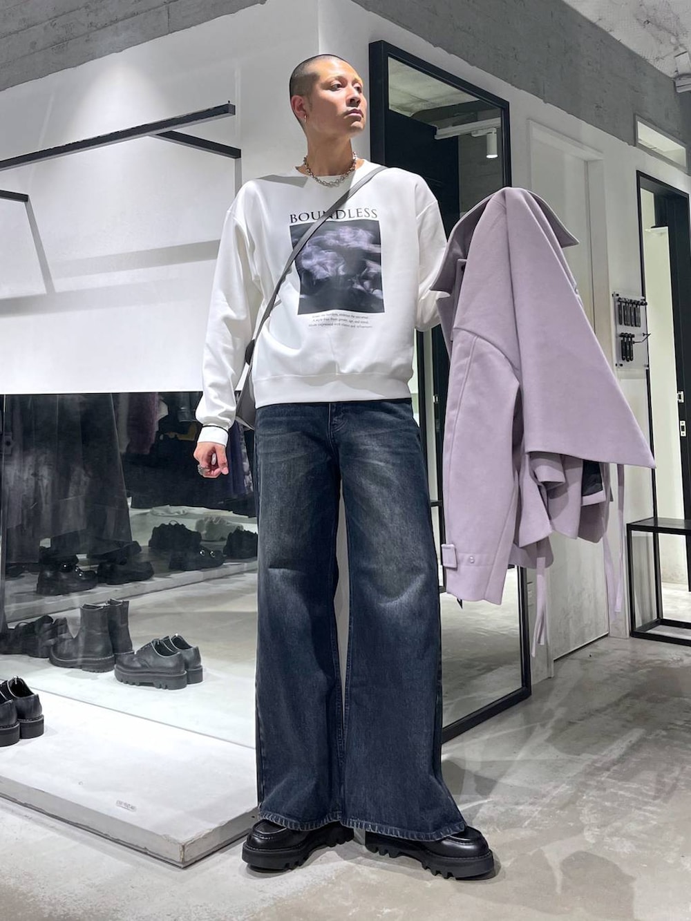 パープル系のブルゾン、ブルー系のデニムパンツ、ブラック系のドレスシューズを着用したメンズの秋コーディネートの6枚目の写真