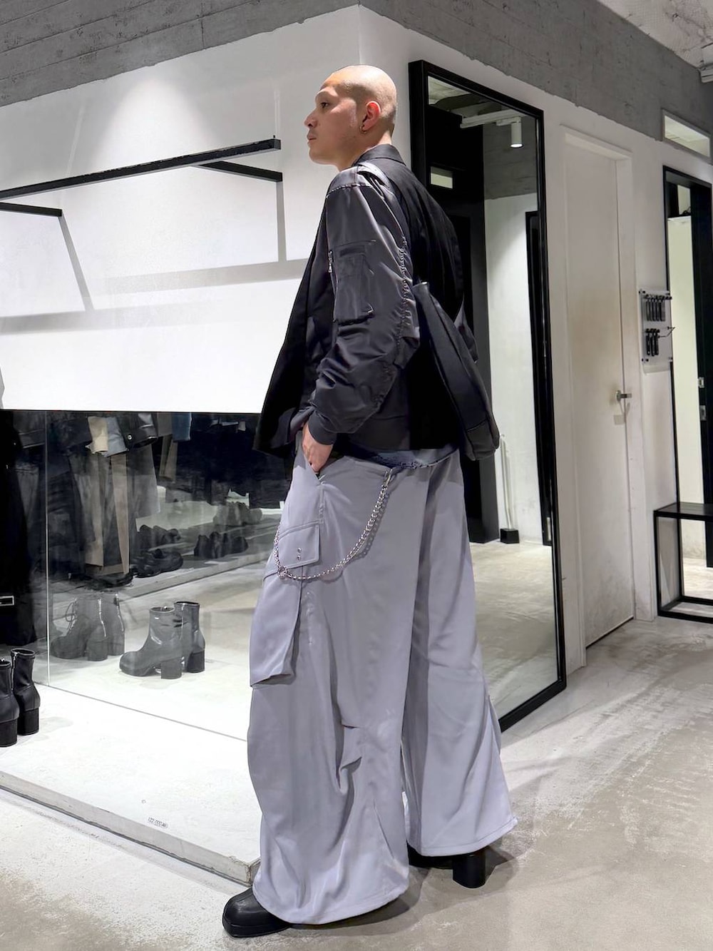 ブラック系のブーツ、ブラック系のショルダーバッグ、ブラック系のテーラードジャケットを着用したメンズの冬コーディネートの2枚目の写真