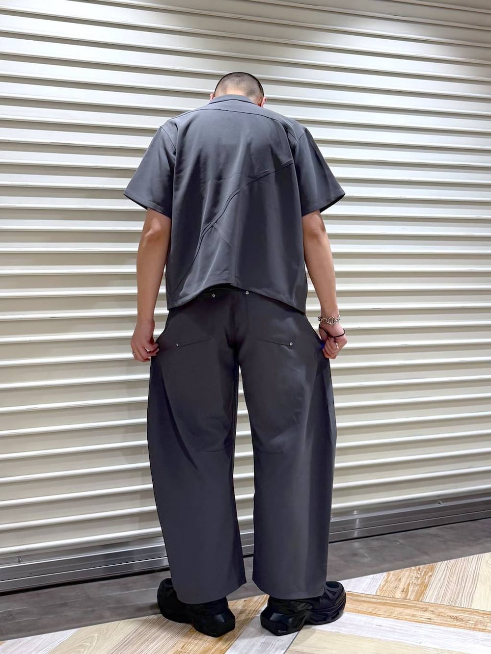 ブラック系のスニーカー、シルバー系のネックレスを着用したメンズの夏コーディネートの3枚目の写真