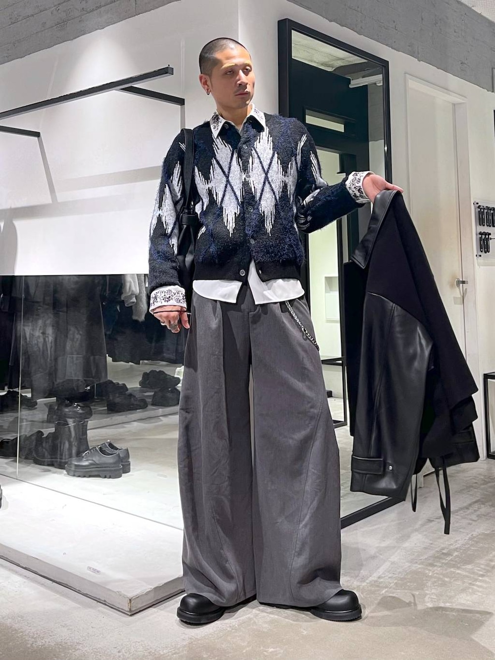 ブラック系のブルゾン、ブラック系のトートバッグ、グレー系のスラックスを着用したメンズの秋コーディネートの5枚目の写真