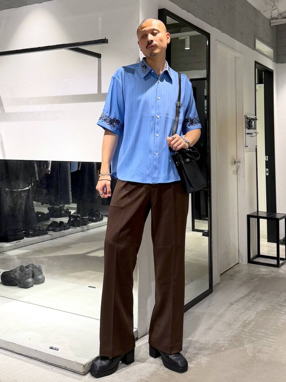 ブルー系のシャツ/ブラウス、ブラウン系のスラックス、ブラック系のサンダルを着用したメンズの夏コーディネートの5枚目の写真