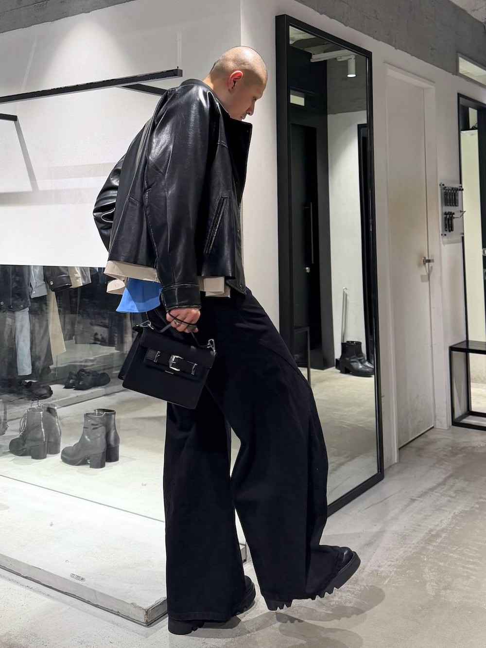 ブルー系のシャツ/ブラウス、ブラック系のドレスシューズ、ブラック系のハンドバッグを着用したメンズの冬コーディネートの4枚目の写真