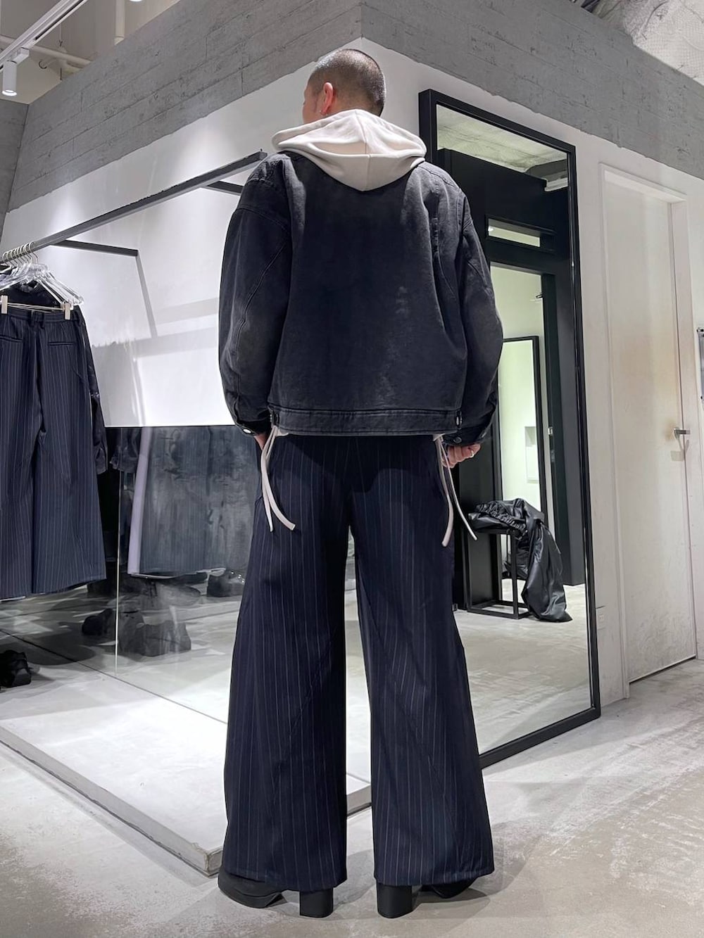 ブルー系のスラックス、ブラック系のブーツ、シルバー系のネックレスを着用したメンズの冬コーディネートの3枚目の写真