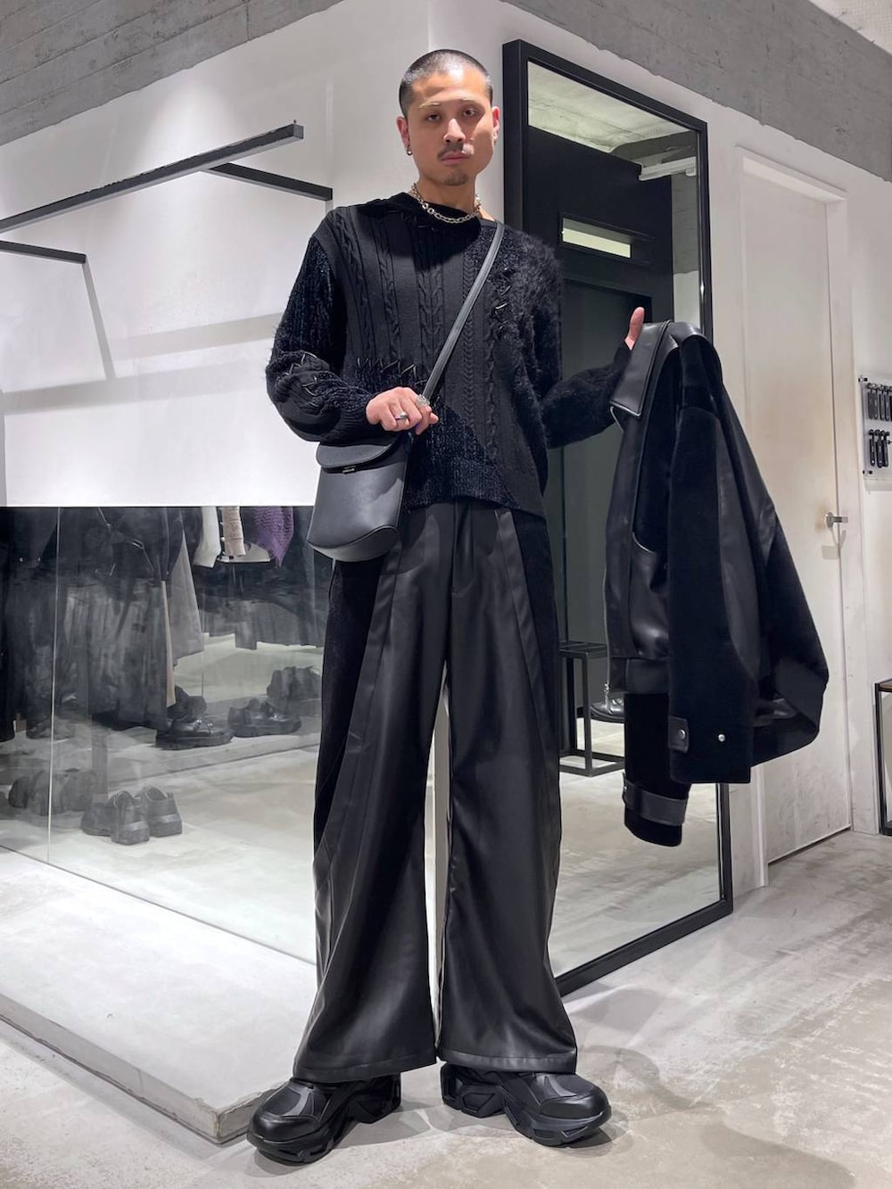 ブラック系のスニーカー、ブラック系のショルダーバッグ、ブラック系のブルゾンを着用したメンズの冬コーディネートの5枚目の写真