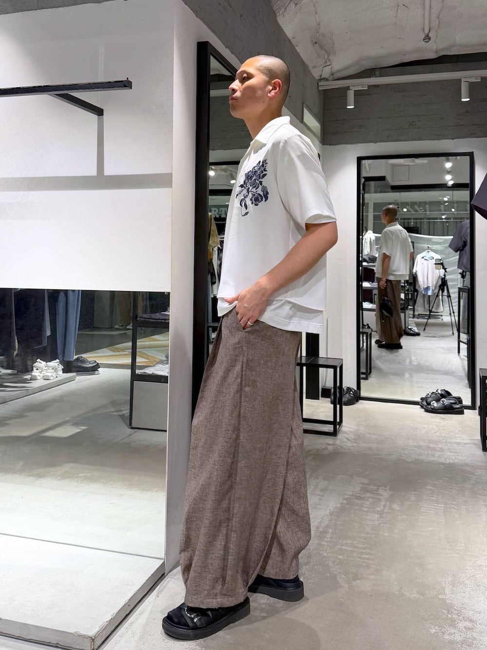 ホワイト系のTシャツ/カットソー、ブラック系のサンダル、ブラック系のショルダーバッグを着用したメンズの夏コーディネートの2枚目の写真