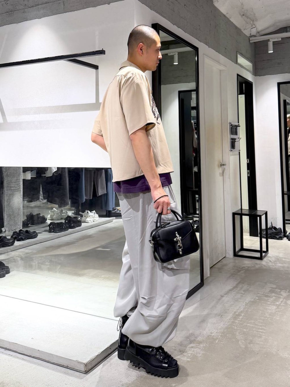 パープル系のTシャツ/カットソー、グレー系のカーゴパンツ、ブラック系のショルダーバッグを着用したメンズの春コーディネートの4枚目の写真