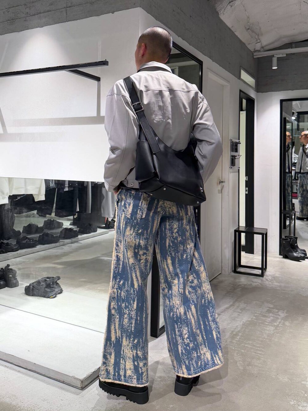 グレー系のブルゾン、ブラック系のショルダーバッグ、ブラック系のサンダルを着用したメンズの春コーディネートの2枚目の写真