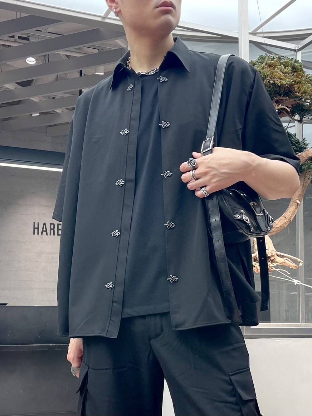 ブラック系のショルダーバッグ、ブラック系のサンダル、ブラック系のカーゴパンツを着用したメンズの夏コーディネートの2枚目の写真