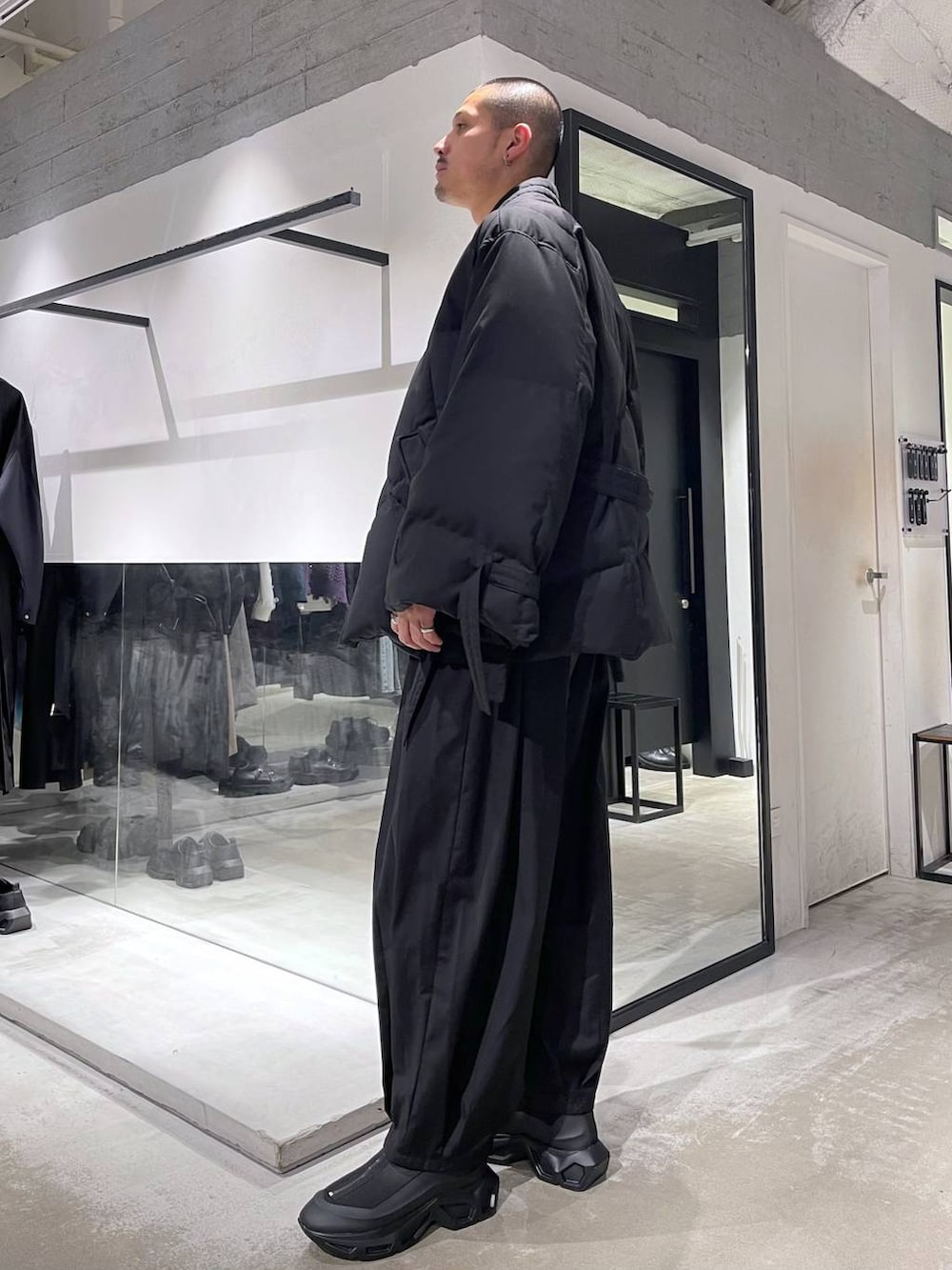 グレー系のカーディガン/ボレロ、ブラック系のダウンジャケット/コート、ブラック系のブーツを着用したメンズの冬コーディネートの2枚目の写真