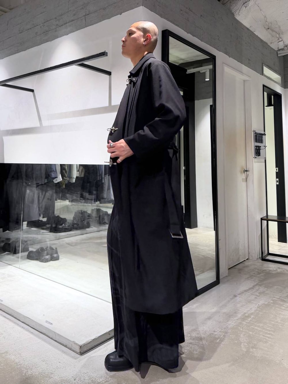 グレー系のその他パンツ、ブラック系のブーツ、ブラック系のハンドバッグを着用したメンズの冬コーディネートの2枚目の写真