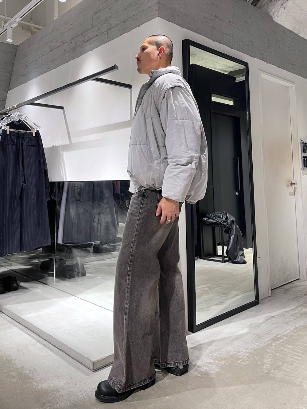 グレー系のダウンジャケット/コート、ブラウン系のデニムパンツ、ブラック系のドレスシューズを着用したメンズの冬コーディネートの2枚目の写真