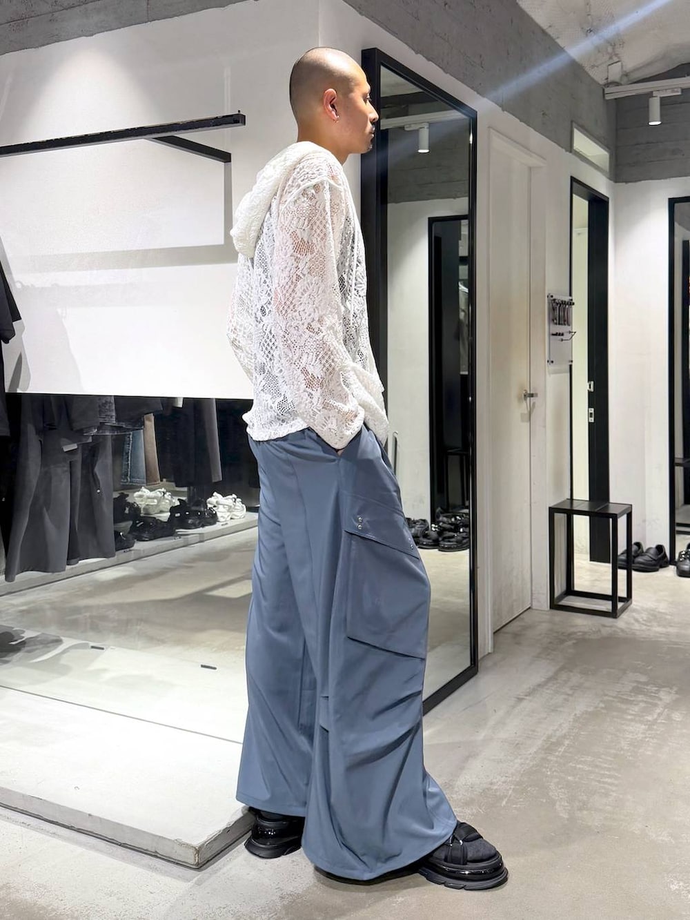ホワイト系のタンクトップ、ブルー系のカーゴパンツ、ブラック系のサンダルを着用したメンズの夏コーディネートの4枚目の写真