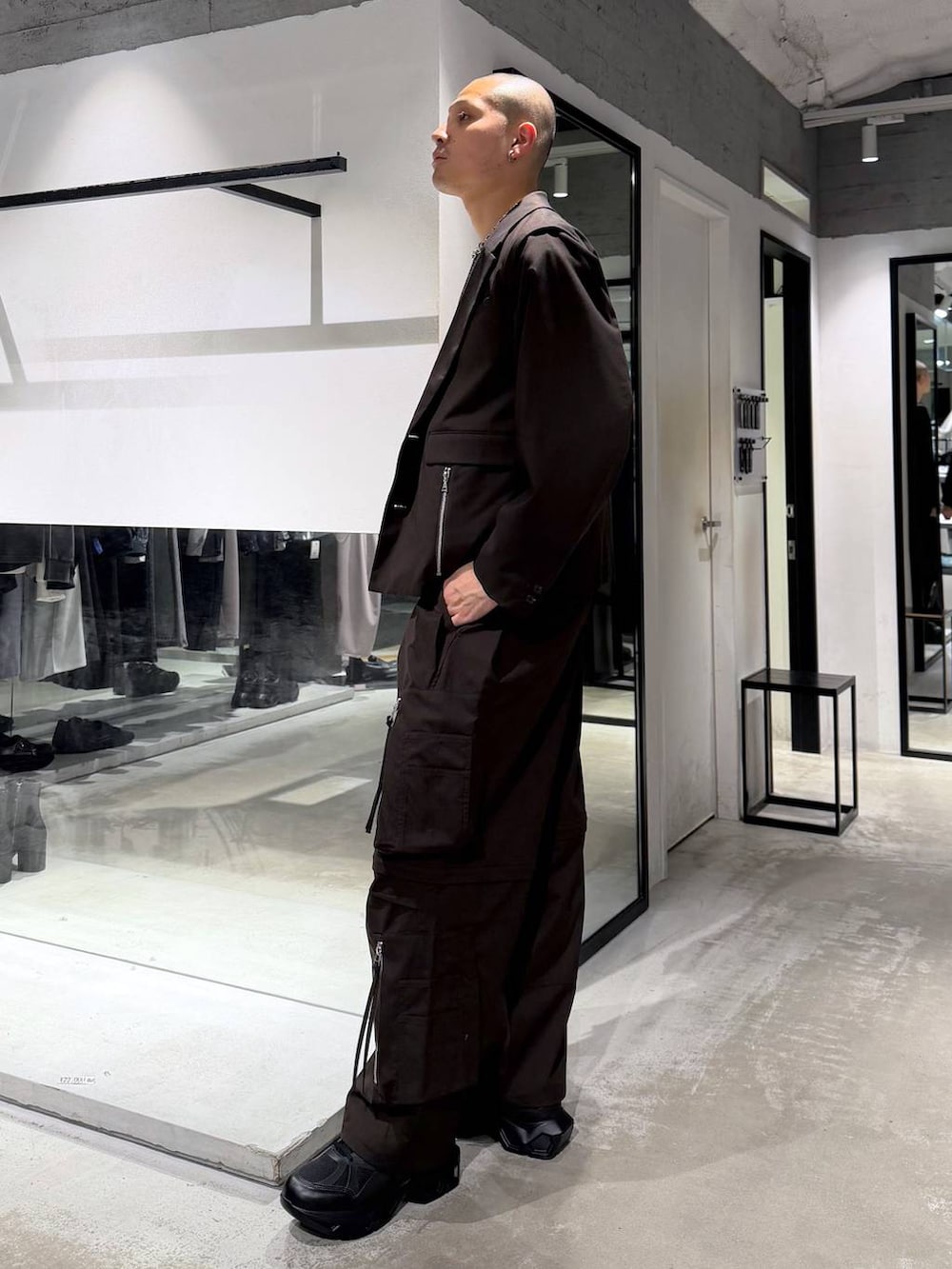 ブラック系のスニーカー、ブラウン系のテーラードジャケット、ブラウン系のカーゴパンツを着用したメンズの春コーディネートの2枚目の写真