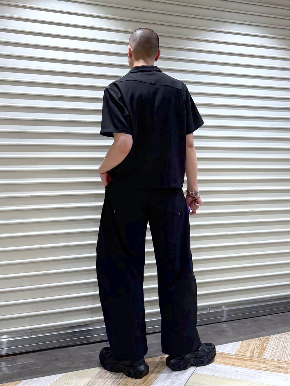 ブラック系のスラックス、ブラック系のシャツ/ブラウス、ブラック系のスニーカーを着用したメンズの夏コーディネートの3枚目の写真