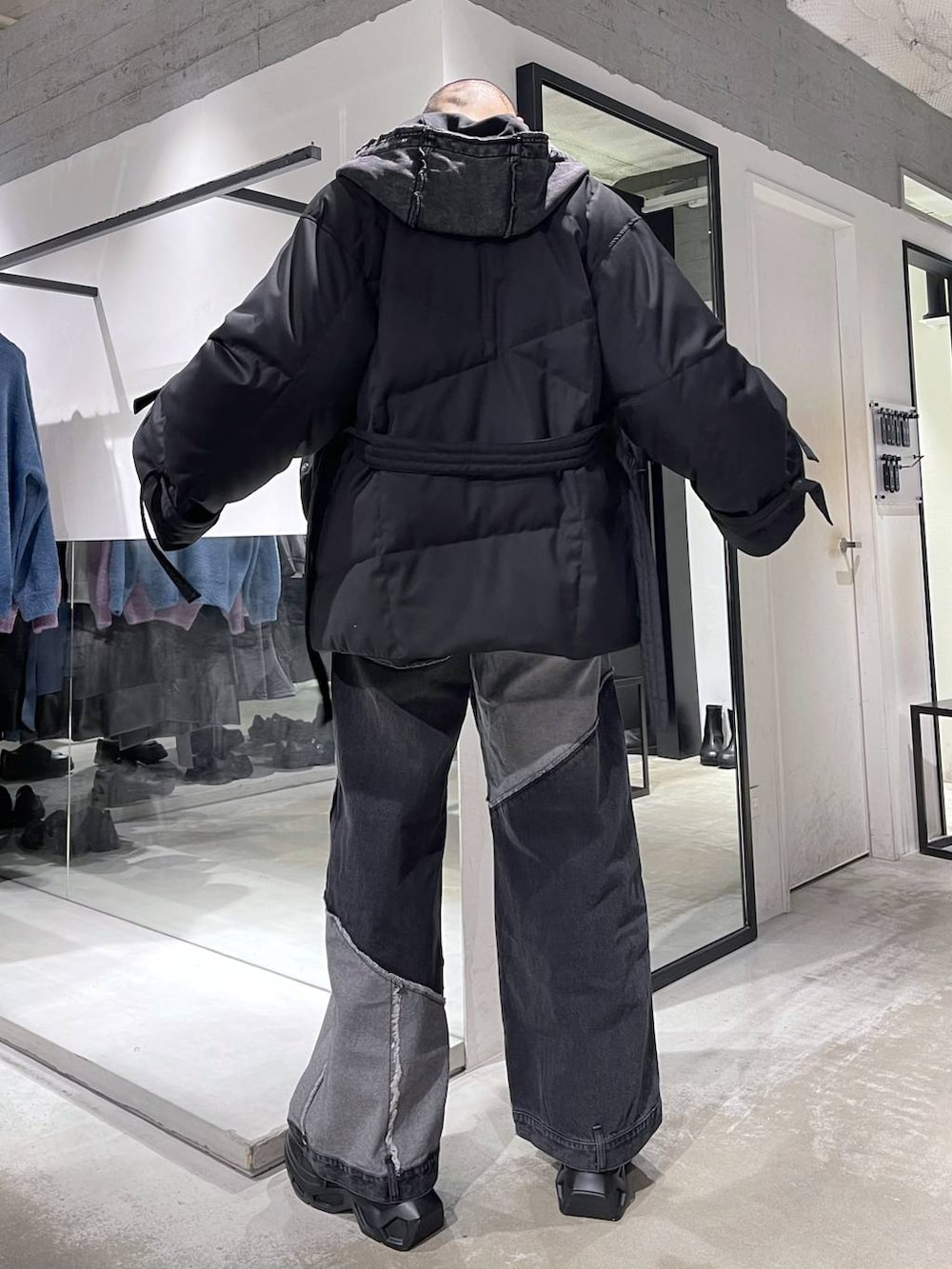 ブラック系のスニーカー、ブラック系のパーカー、ブラック系のデニムパンツを着用したメンズの冬コーディネートの3枚目の写真