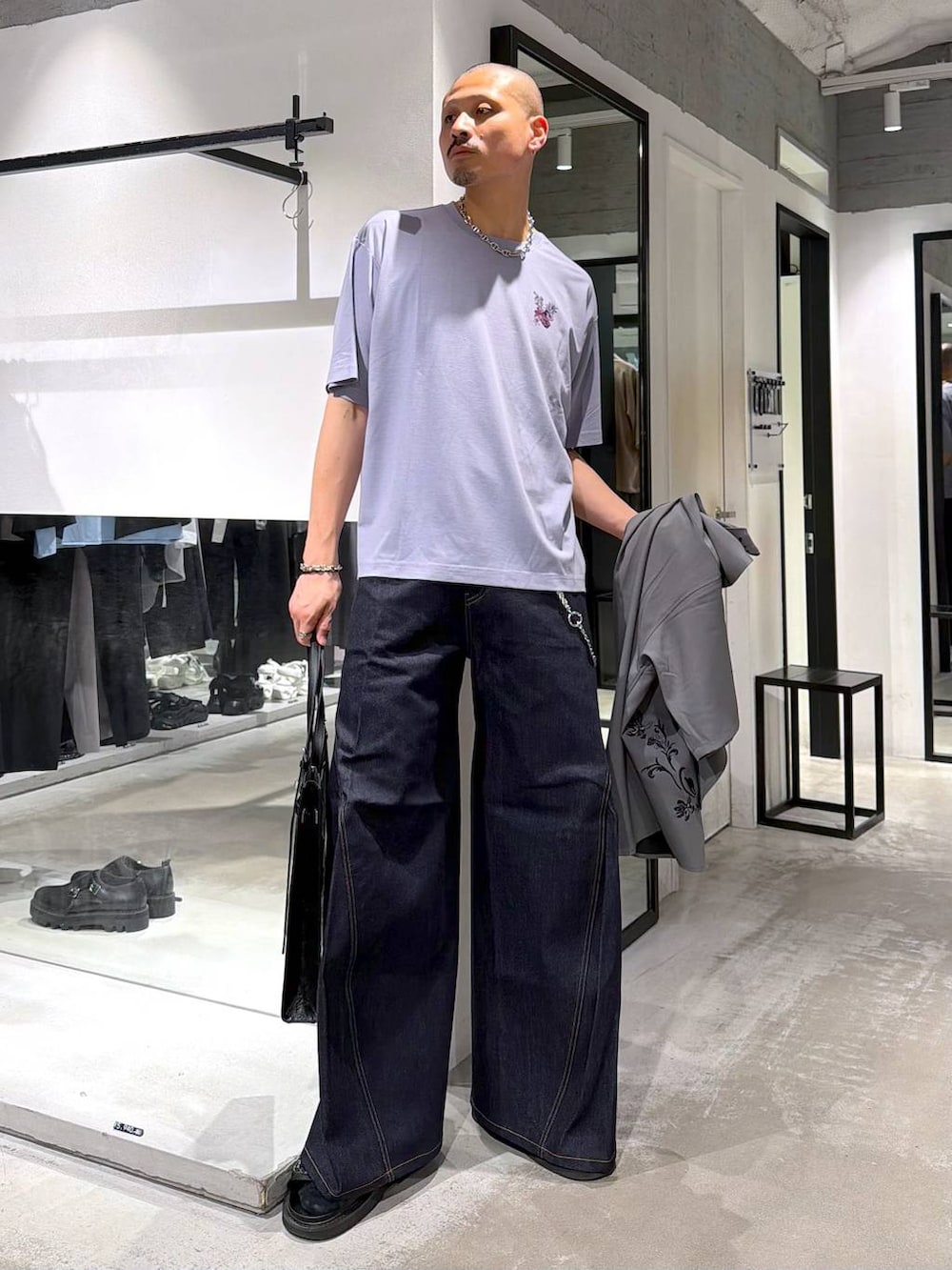 ブルー系のデニムパンツ、ブラック系のサンダル、パープル系のTシャツ/カットソーを着用したメンズの夏コーディネートの6枚目の写真