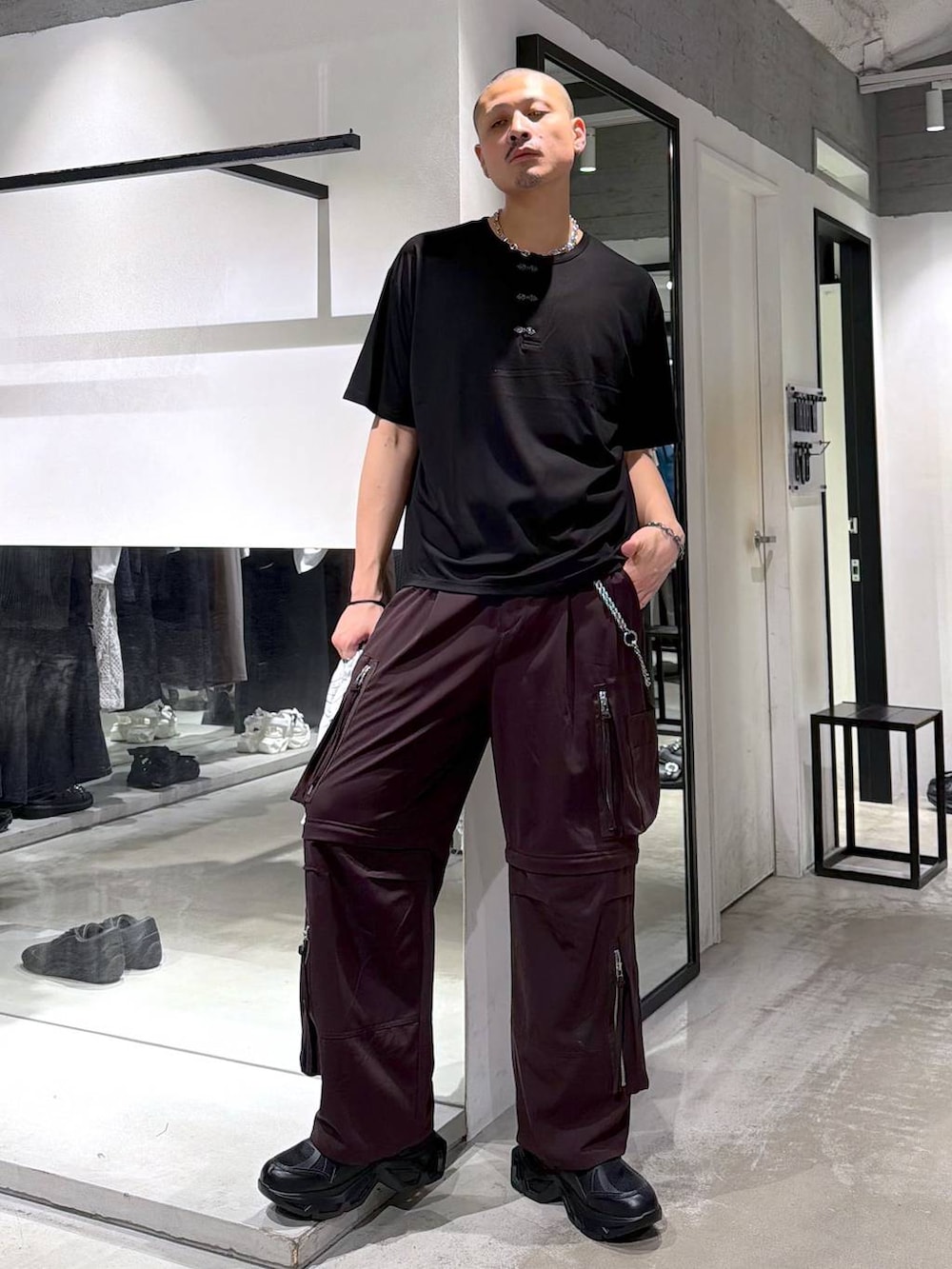 ブラック系のスニーカー、ブラウン系のカーゴパンツ、ブラック系のショルダーバッグを着用したメンズの夏コーディネートの5枚目の写真