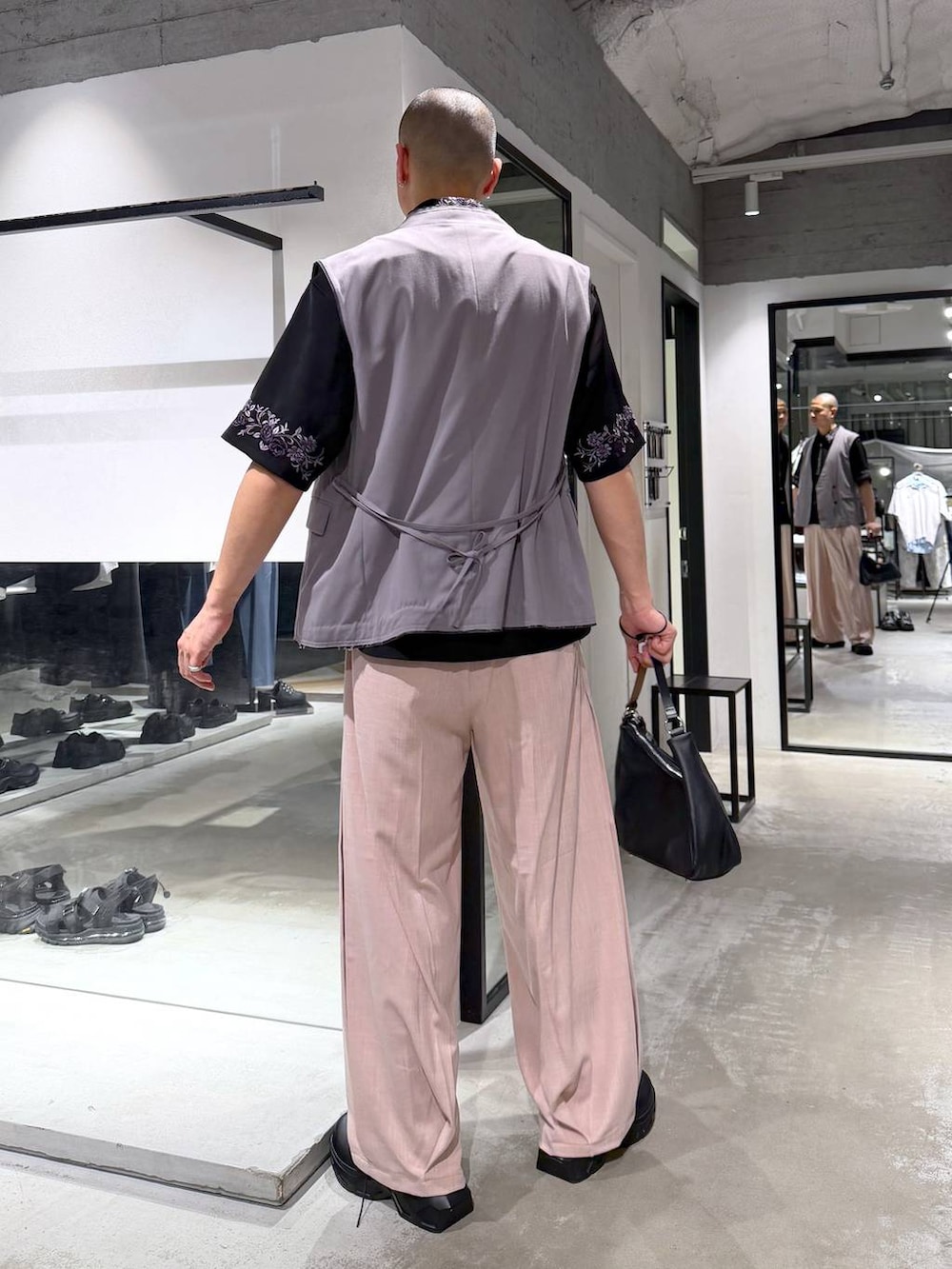 ブラック系のシャツ/ブラウス、ブラック系のドレスシューズ、ブラウン系のベストを着用したメンズの春コーディネートの3枚目の写真