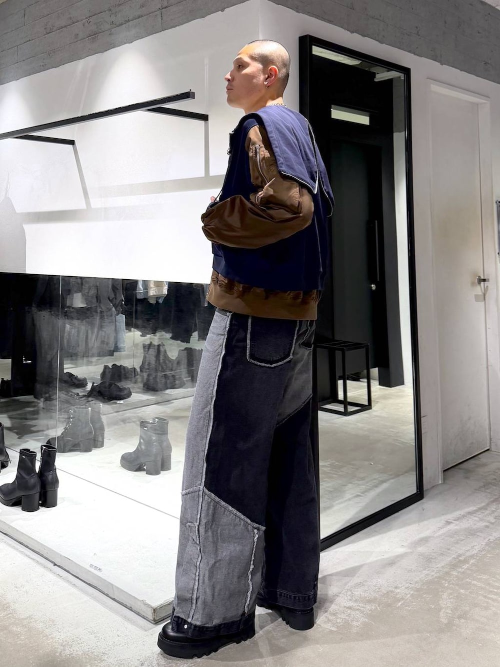 ブラック系のデニムパンツ、ブラック系のドレスシューズ、グレー系のニット/セーターを着用したメンズの冬コーディネートの2枚目の写真