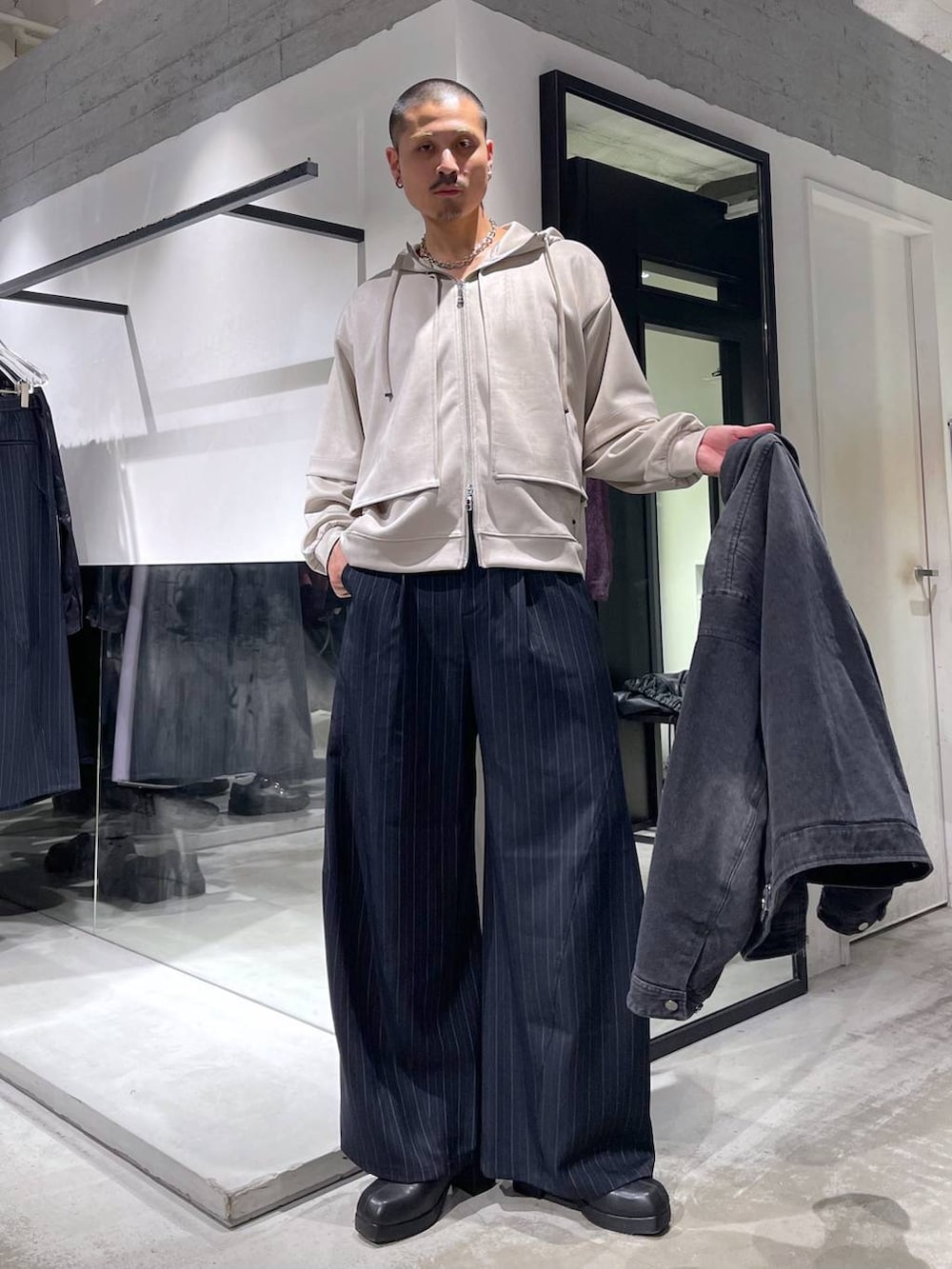 ブルー系のスラックス、ブラック系のブーツ、シルバー系のネックレスを着用したメンズの冬コーディネートの5枚目の写真