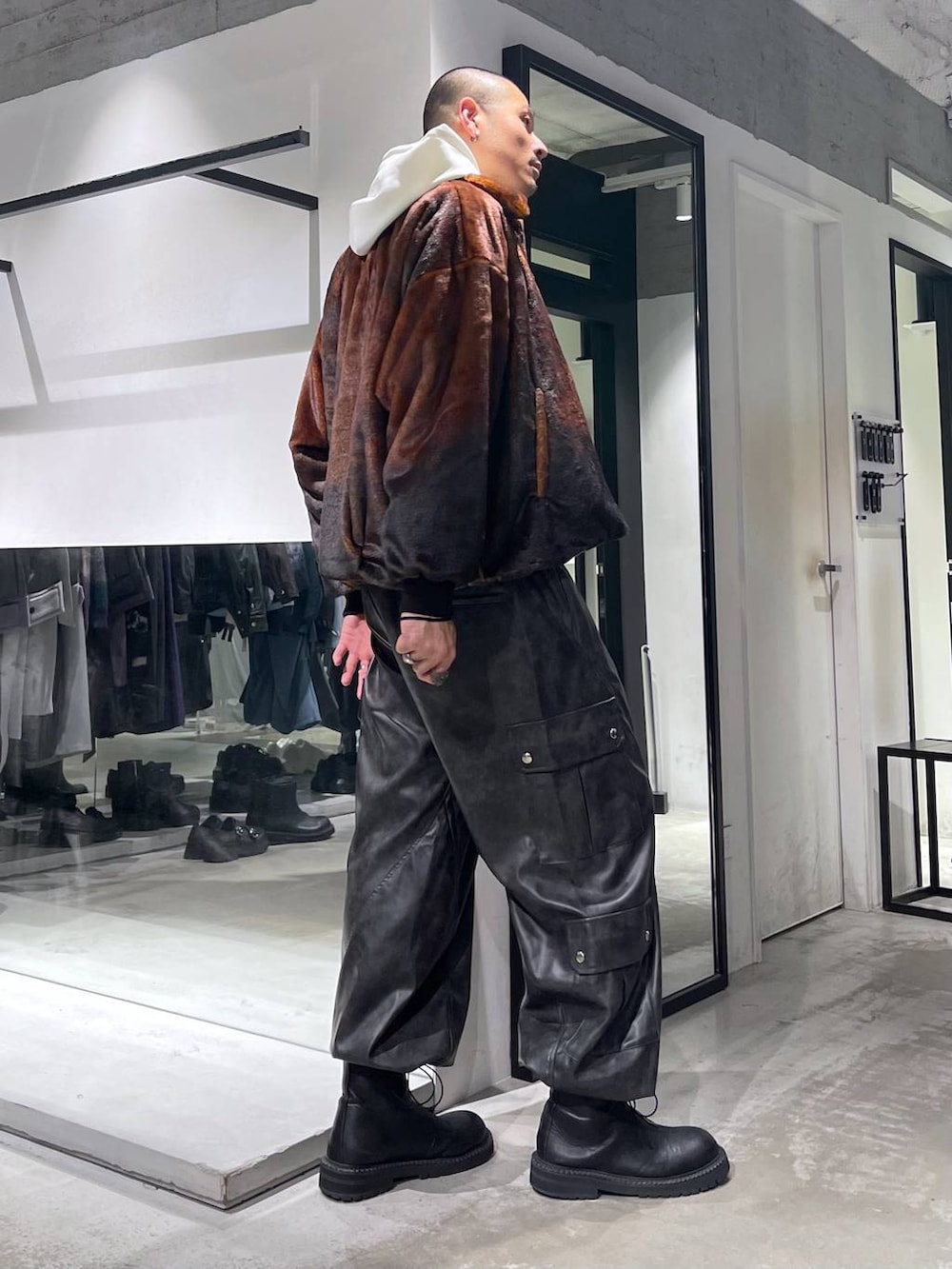 オレンジ系のブルゾン、グレー系のカーゴパンツ、ブラック系のブーツを着用したメンズの秋コーディネートの4枚目の写真