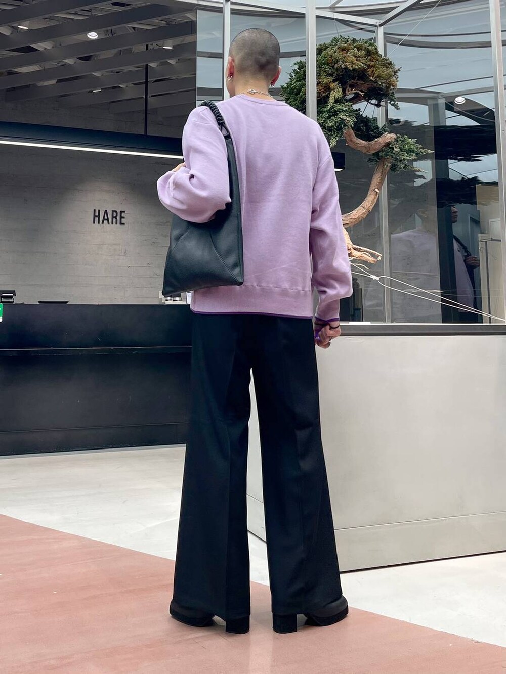 ブラック系のトートバッグ、ブラック系のブーツ、ブラック系のスラックスを着用したメンズの秋コーディネートの3枚目の写真