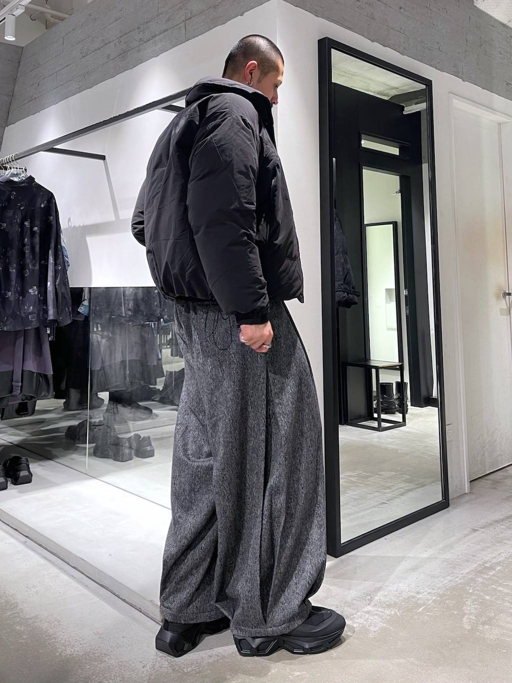 ブラック系のニット/セーター、ブラック系のダウンジャケット/コート、ブラック系のスラックスを着用したメンズの冬コーディネートの4枚目の写真