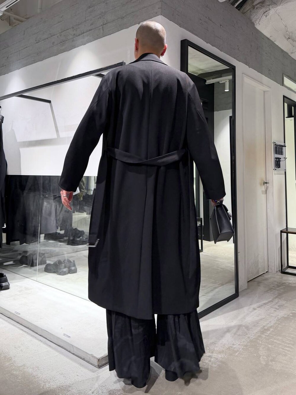 グレー系のその他パンツ、ブラック系のブーツ、ブラック系のハンドバッグを着用したメンズの冬コーディネートの3枚目の写真
