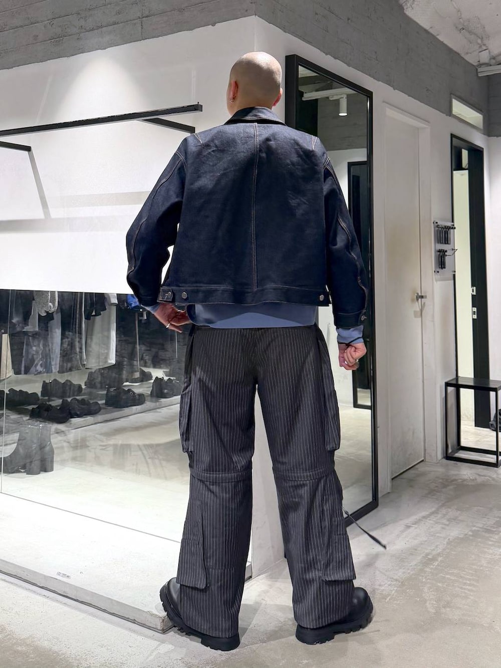 ブルー系のデニムジャケット、ブラック系のドレスシューズ、グレー系のカーゴパンツを着用したメンズの春コーディネートの3枚目の写真