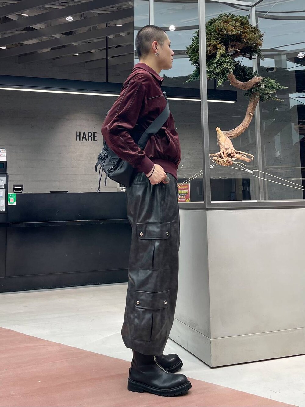 グレー系のカーゴパンツ、ブラック系のメッセンジャーバッグ、ブラック系のブーツを着用したメンズの秋コーディネートの4枚目の写真