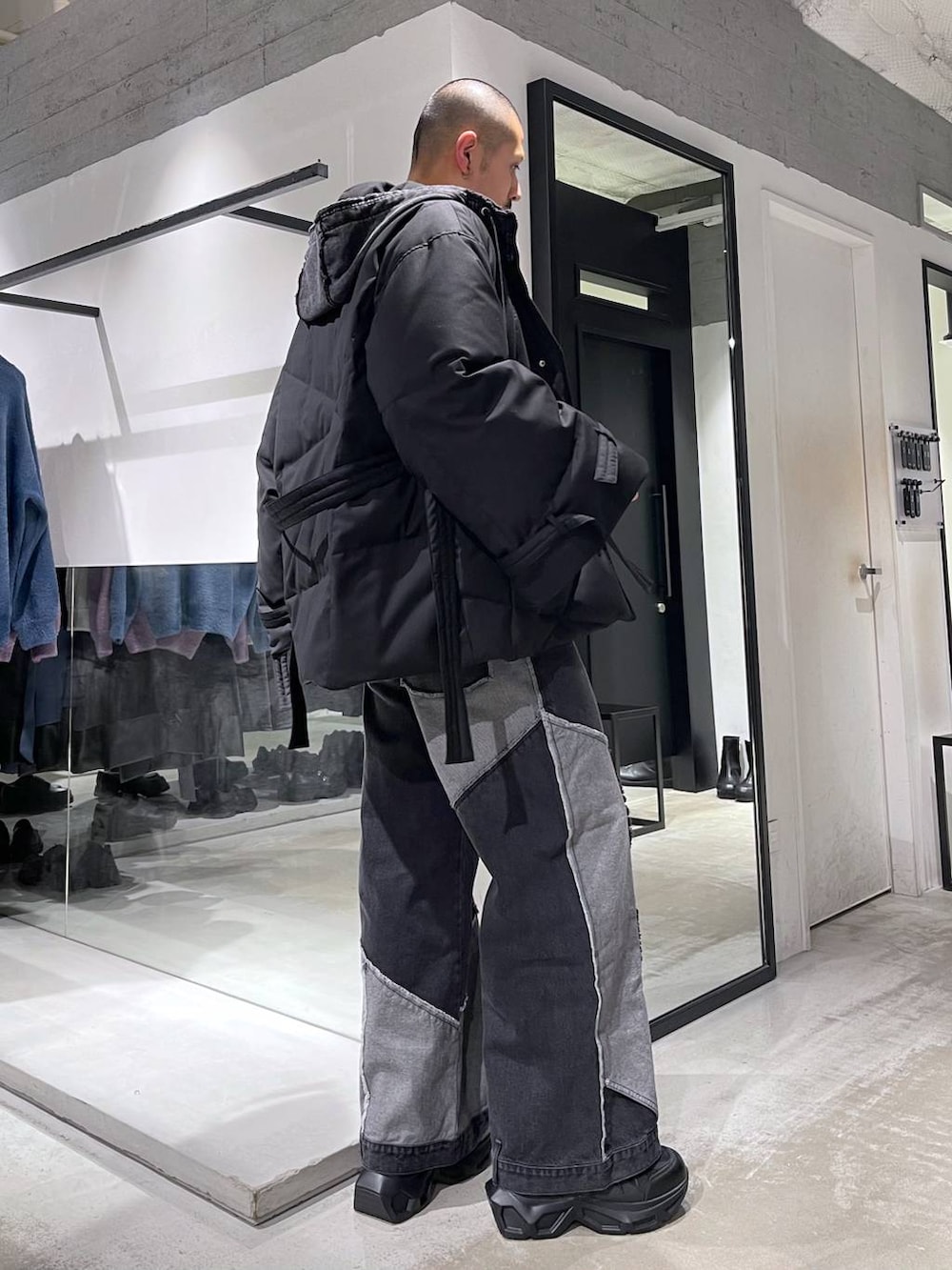 ブラック系のスニーカー、ブラック系のパーカー、ブラック系のデニムパンツを着用したメンズの冬コーディネートの4枚目の写真