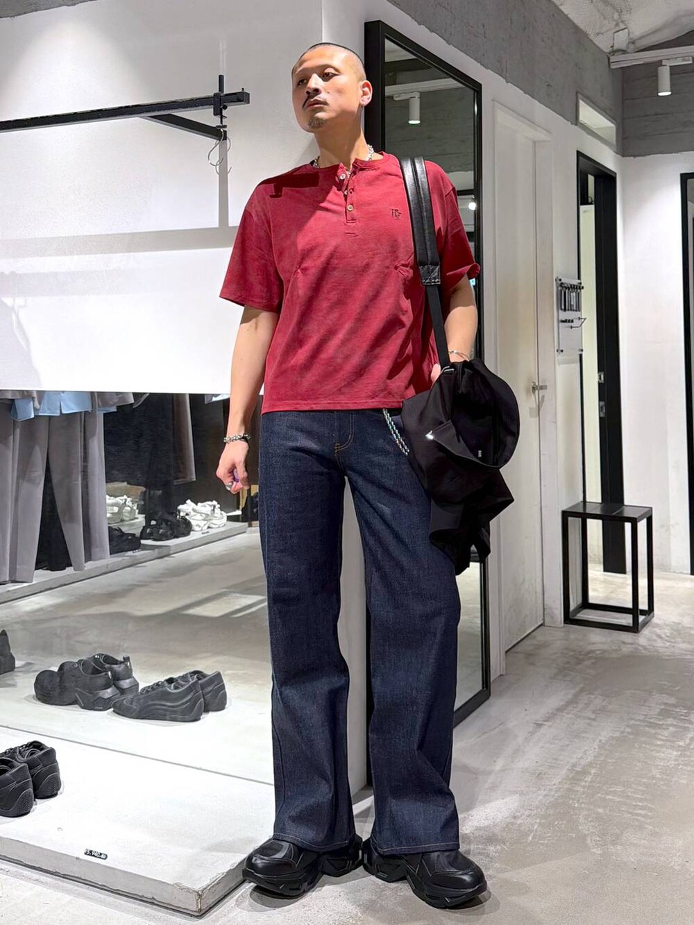 ブラック系のスニーカー、レッド系のTシャツ/カットソー、ブルー系のデニムパンツを着用したメンズの夏コーディネートの6枚目の写真