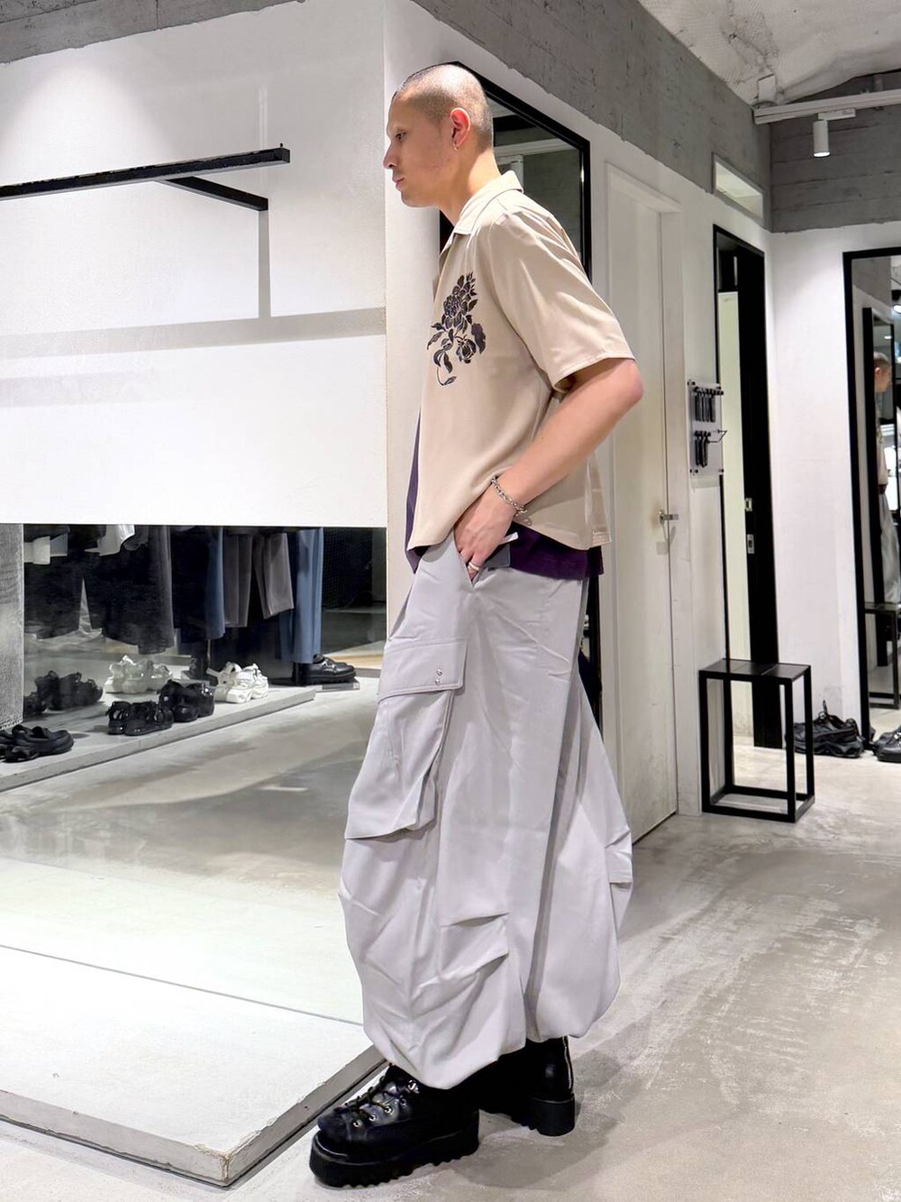 パープル系のTシャツ/カットソー、グレー系のカーゴパンツ、ブラック系のショルダーバッグを着用したメンズの春コーディネートの2枚目の写真