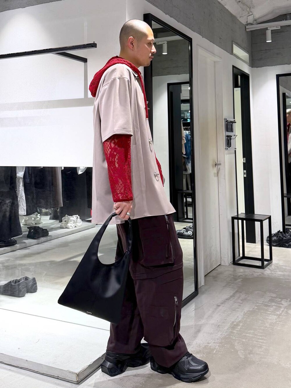 ブラック系のトートバッグ、ブラック系のスニーカー、ブラウン系のカーゴパンツを着用したメンズの春コーディネートの4枚目の写真