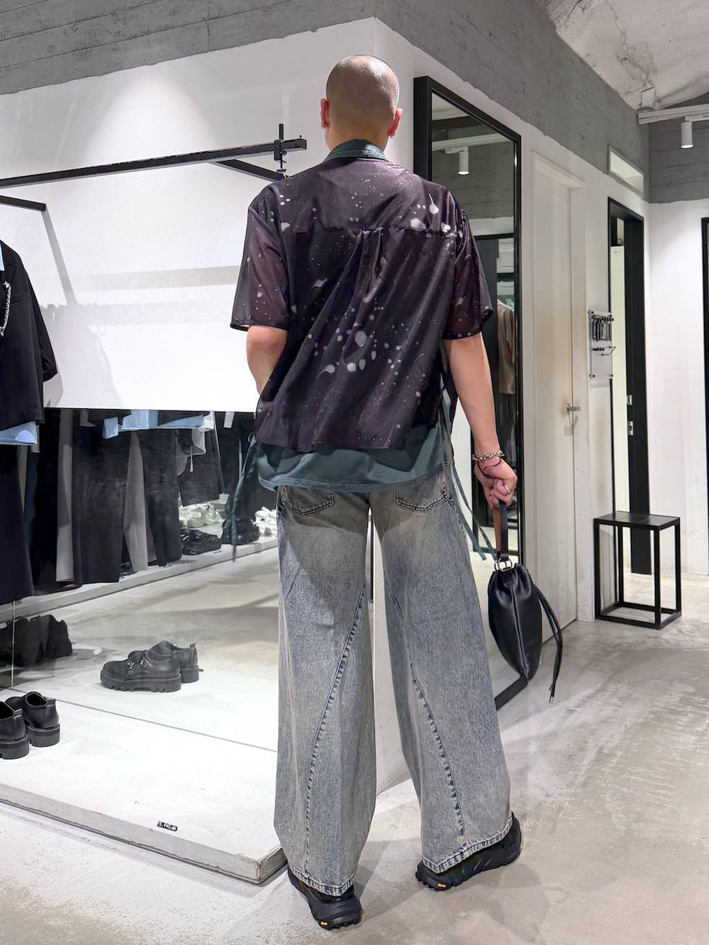 ブルー系のデニムパンツ、ブラック系のサンダル、ブラック系のショルダーバッグを着用したメンズの夏コーディネートの3枚目の写真
