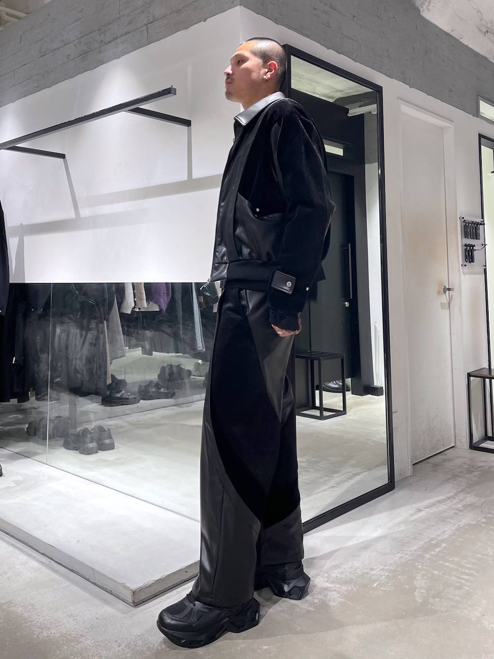 ブラック系のスニーカー、ブラック系のショルダーバッグ、ブラック系のブルゾンを着用したメンズの冬コーディネートの2枚目の写真