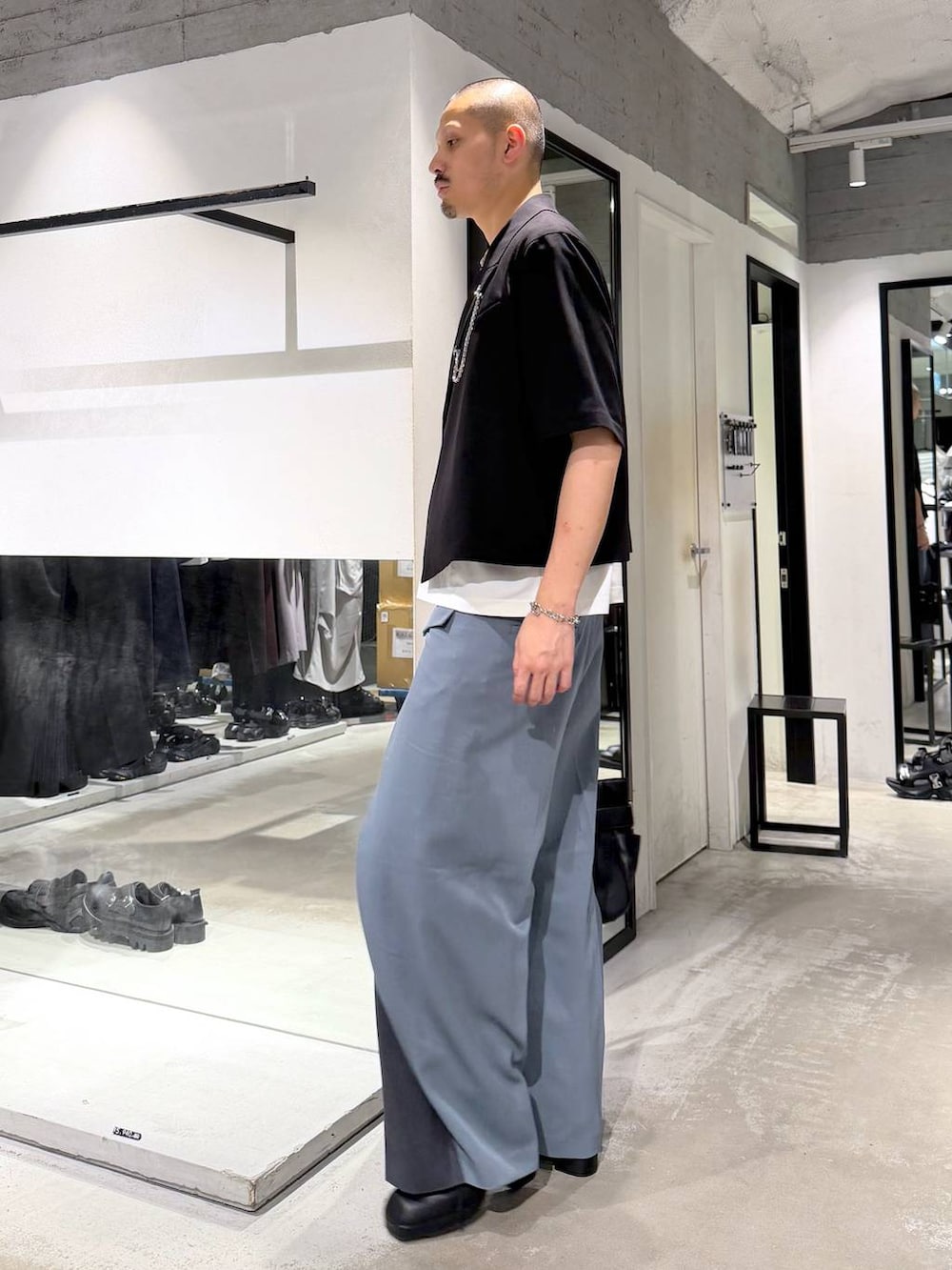 ブラック系のサンダル、ブルー系のスラックス、ホワイト系のTシャツ/カットソーを着用したメンズの夏コーディネートの2枚目の写真
