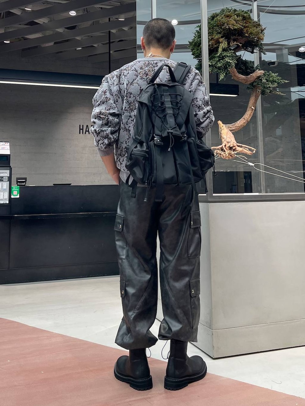 グレー系のニット/セーター、グレー系のカーゴパンツ、ブラック系のバックパック/リュックを着用したメンズの秋コーディネートの3枚目の写真