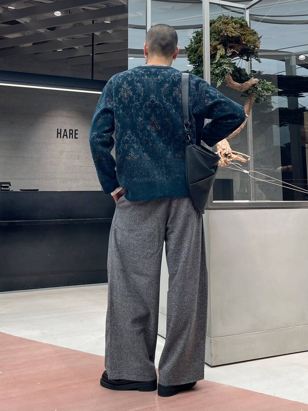 グリーン系のカーディガン/ボレロ、ブラック系のローファー、ブラック系のスラックスを着用したメンズの秋コーディネートの3枚目の写真