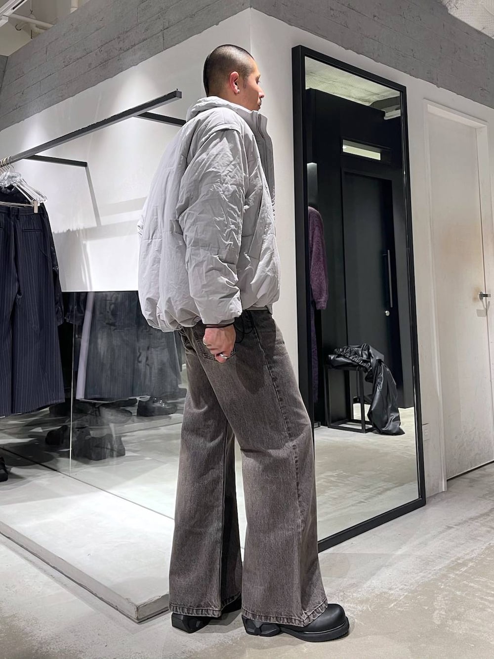 グレー系のダウンジャケット/コート、ブラウン系のデニムパンツ、ブラック系のドレスシューズを着用したメンズの冬コーディネートの4枚目の写真