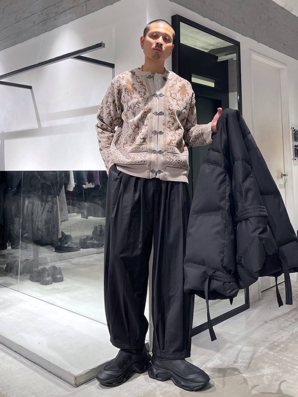 グレー系のカーディガン/ボレロ、ブラック系のダウンジャケット/コート、ブラック系のブーツを着用したメンズの冬コーディネートの5枚目の写真