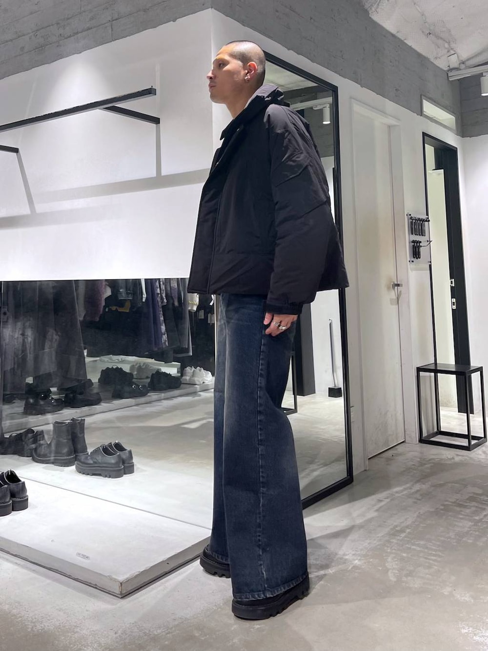 ブラック系のダウンジャケット/コート、ブルー系のデニムパンツ、ブラック系のブルゾンを着用したメンズの秋コーディネートの2枚目の写真