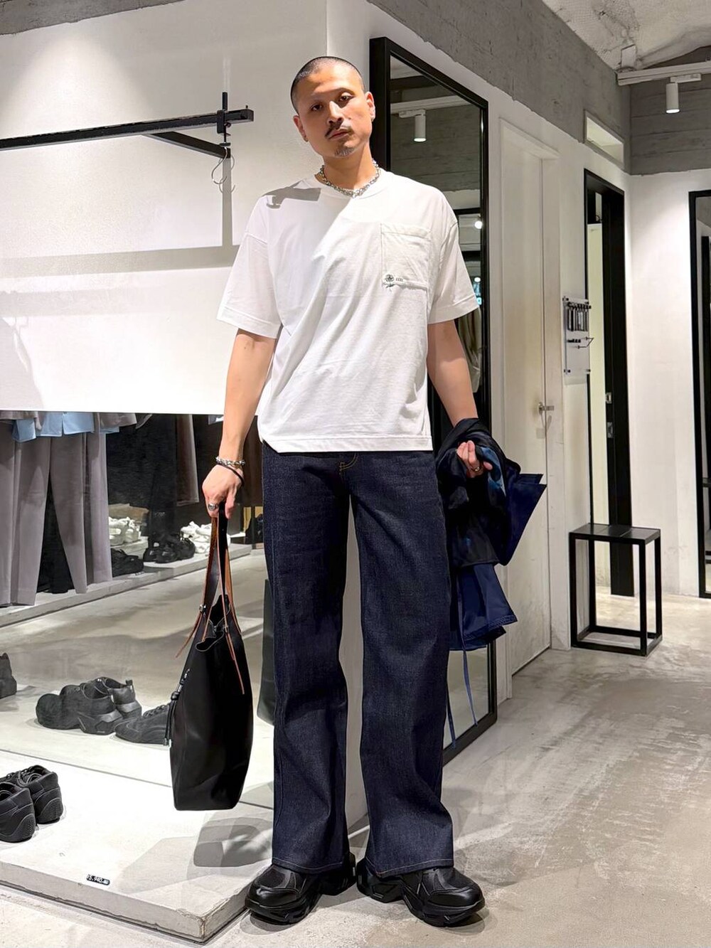 ブラック系のスニーカー、ホワイト系のTシャツ/カットソー、ブラック系のトートバッグを着用したメンズの夏コーディネートの5枚目の写真