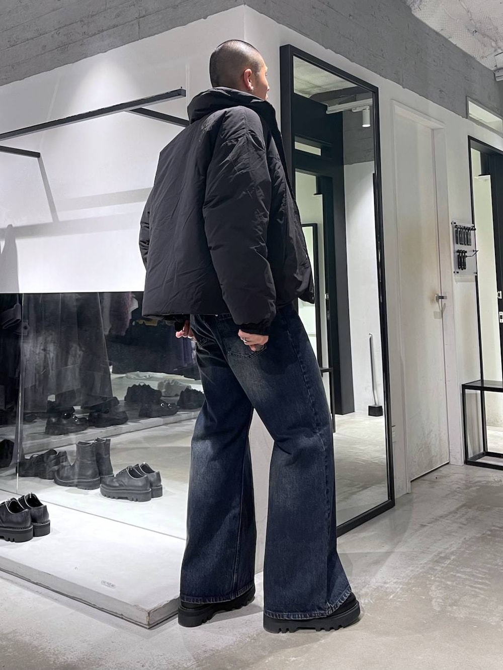 ブラック系のダウンジャケット/コート、ブルー系のデニムパンツ、ブラック系のブルゾンを着用したメンズの秋コーディネートの4枚目の写真