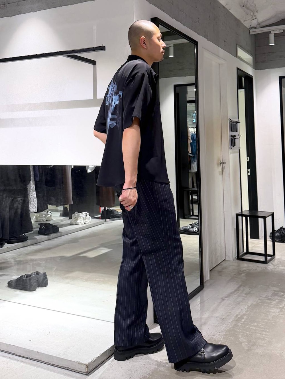 ブルー系のスラックス、ブラック系のドレスシューズ、ブルー系のTシャツ/カットソーを着用したメンズの夏コーディネートの4枚目の写真